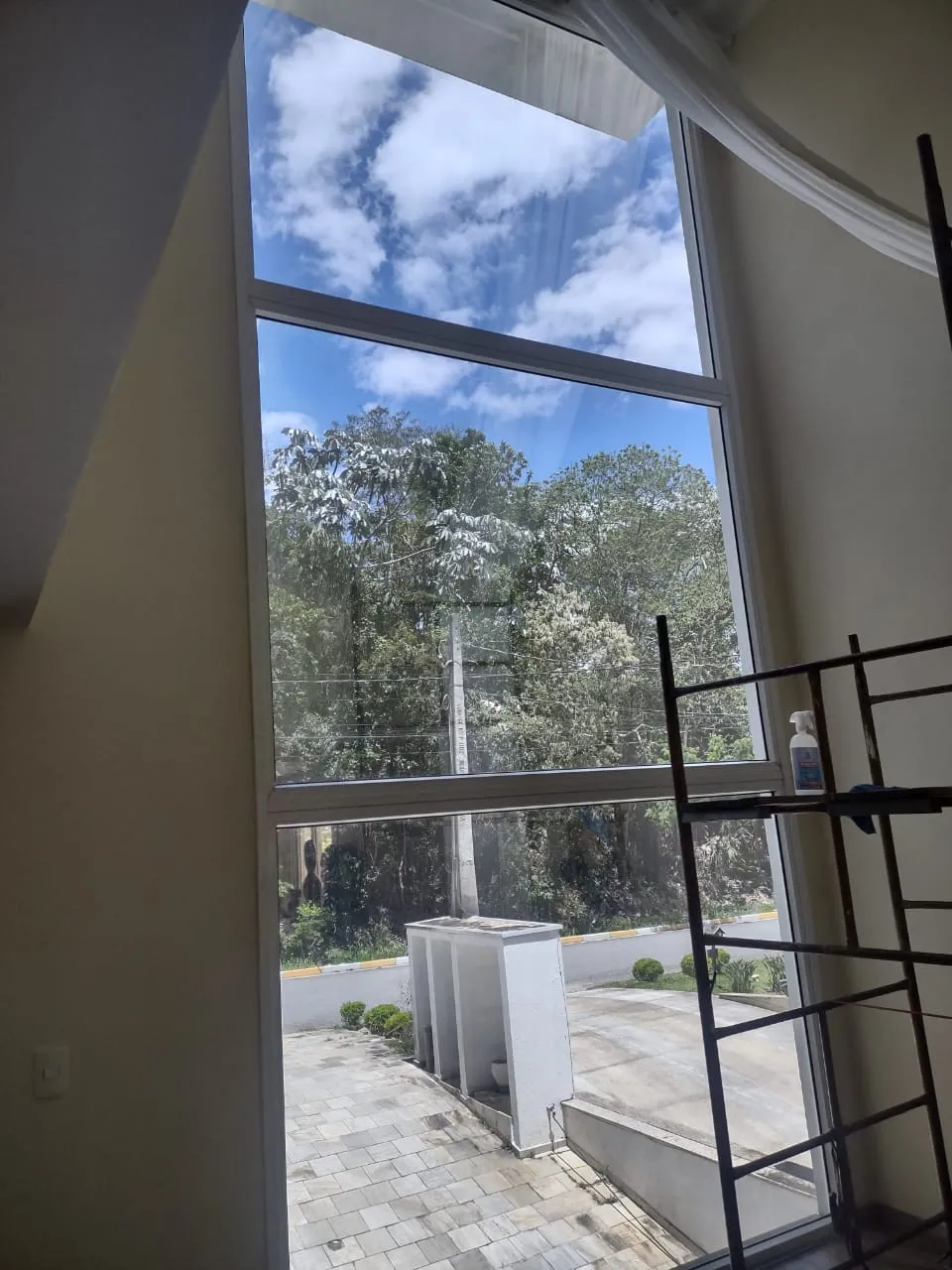 Película residencial instalada em janela ampla com vista para área verde